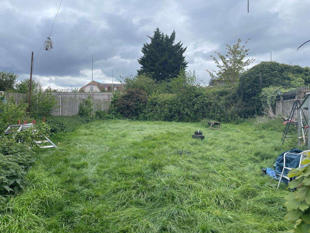 Lot: 28 - DETACHED TWO-BEDROOM BUNGALOW - Rear garden with overgrown bush to rear